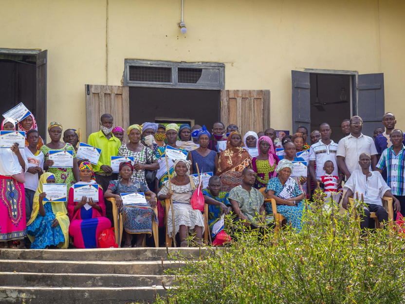 title Community in Ghana holding up certificates