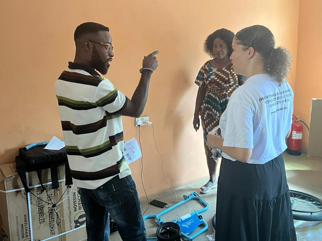 three people standing and talking in a room