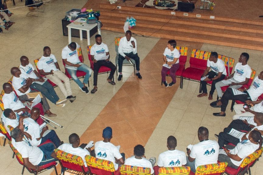 Trainees sitting in a circle of chairs talking